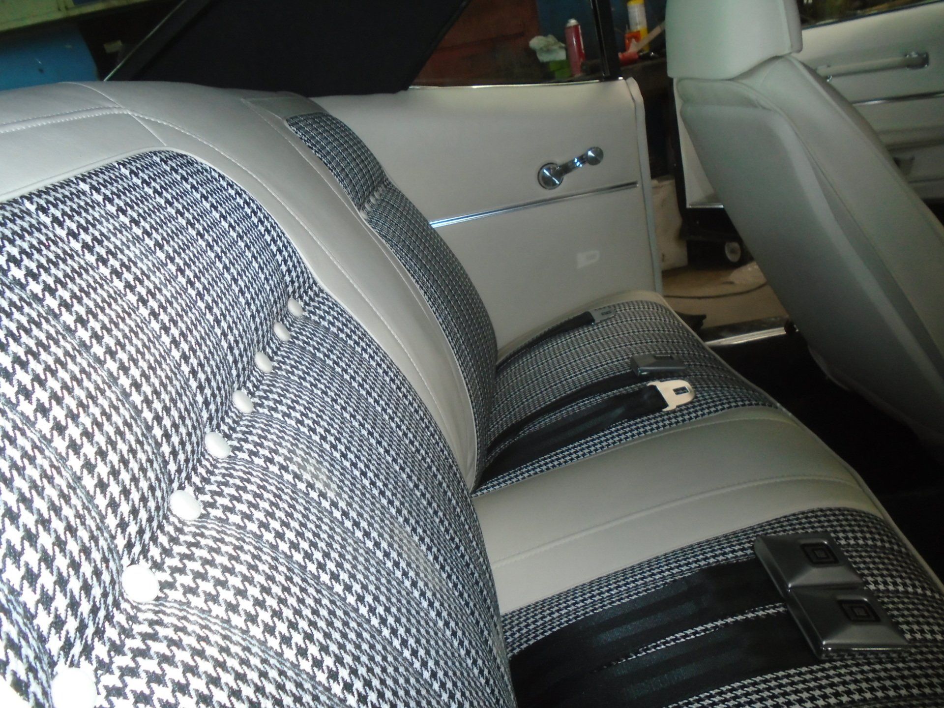 Car interior with houndstooth patterned seats and gray trim.