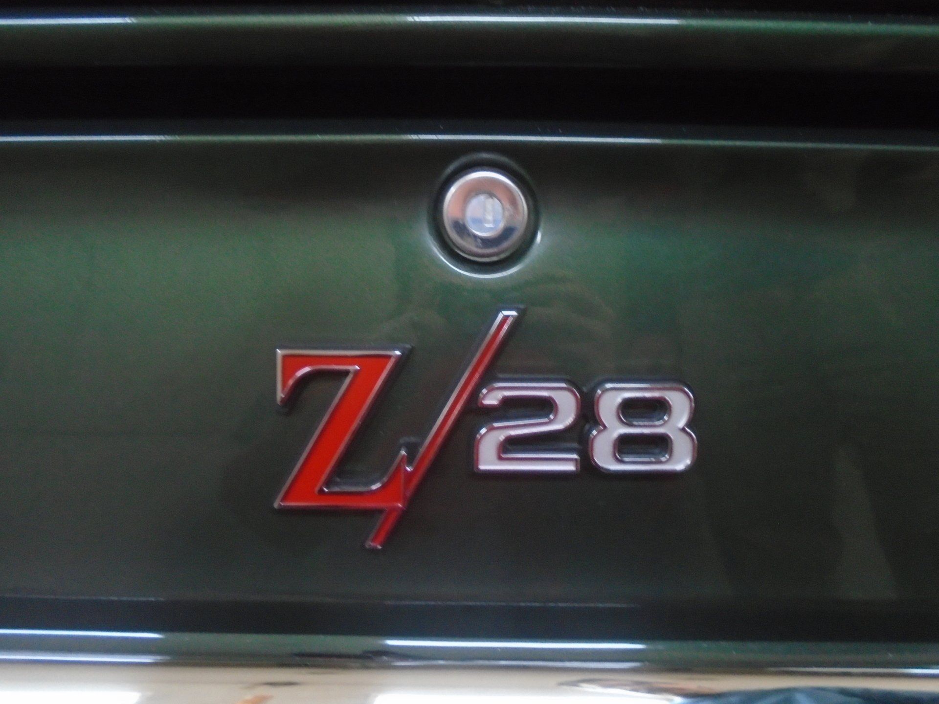 Green car trunk with red and silver Z/28 emblem.