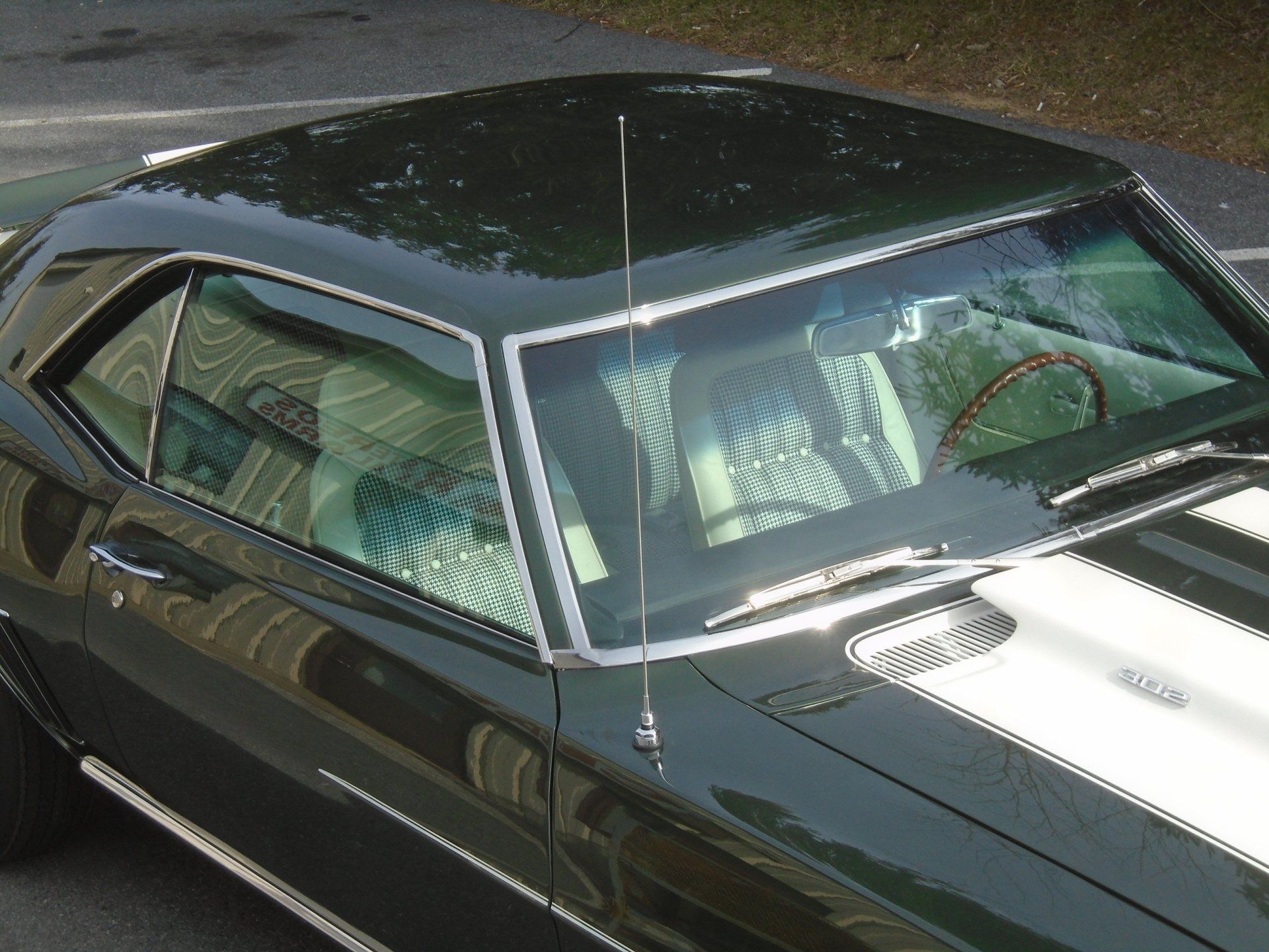 Green classic car with white racing stripes.
