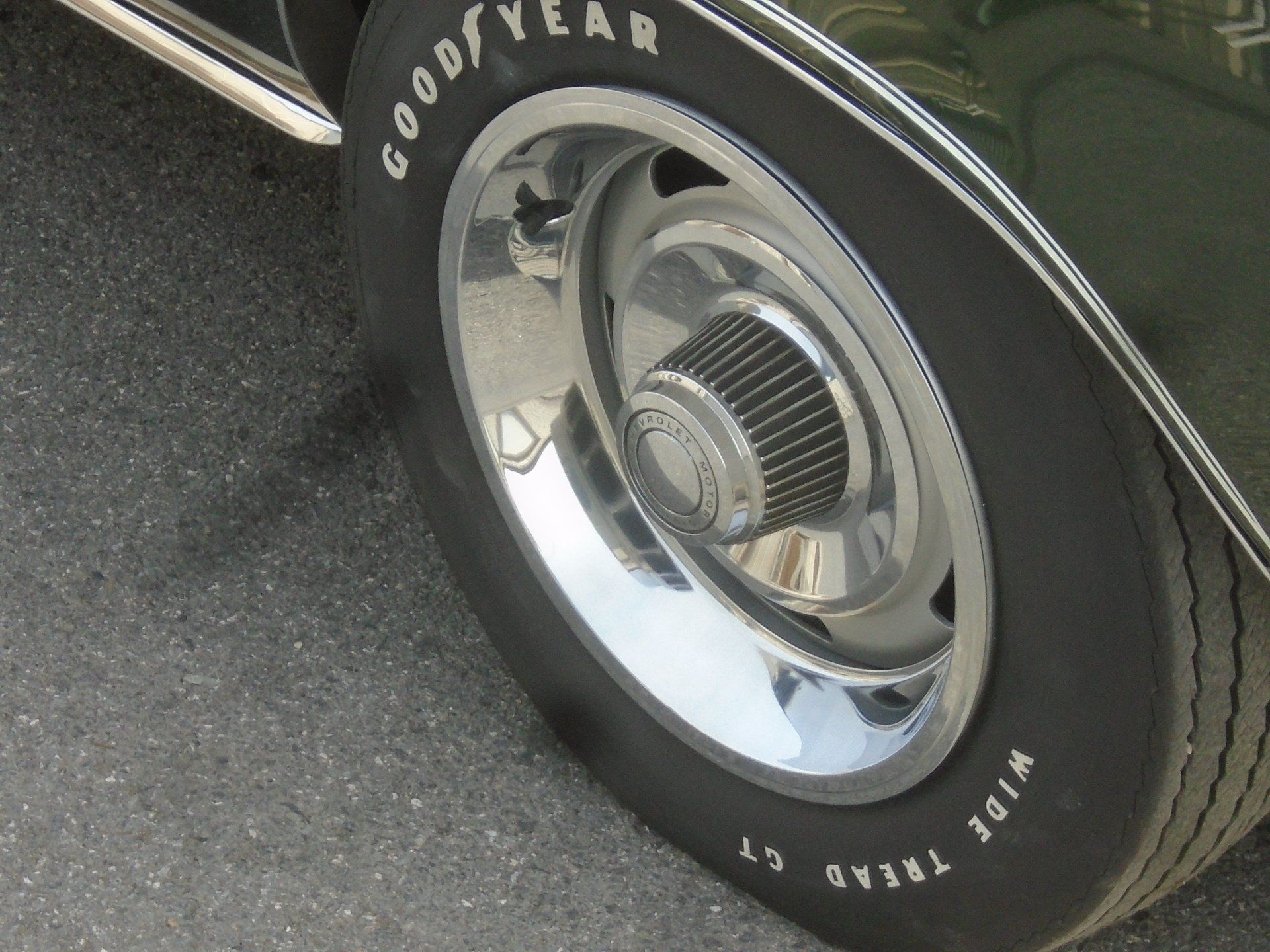 Car wheel with chrome hubcap and white-lettered Goodyear tire.