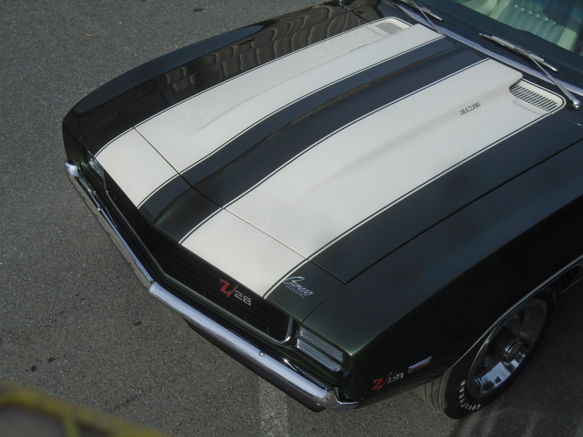 Black classic car hood with white racing stripes; 