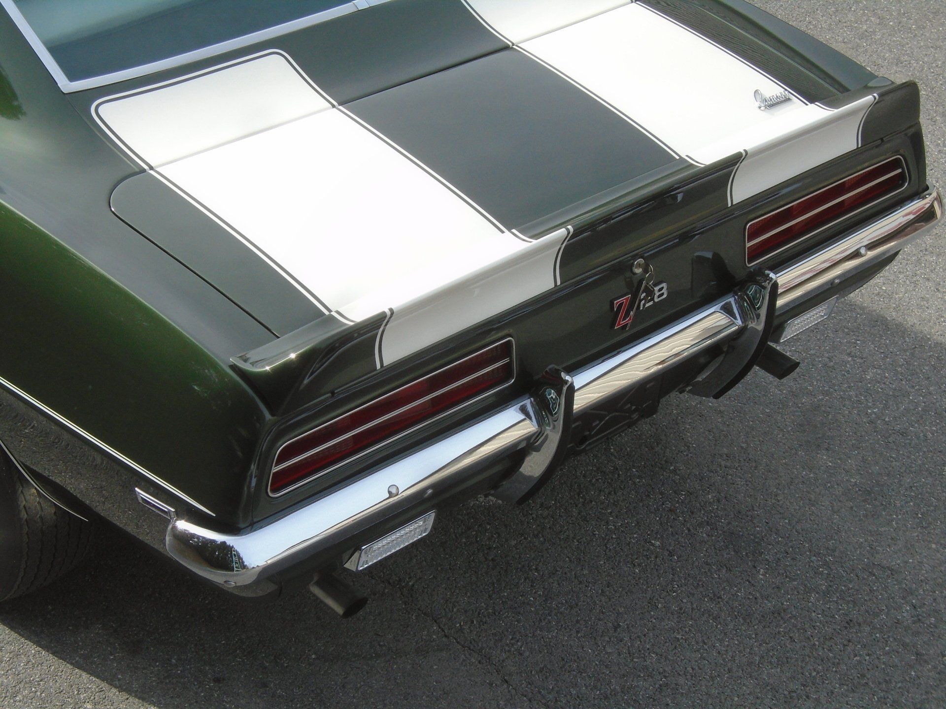 Green classic car rear with white racing stripes, 