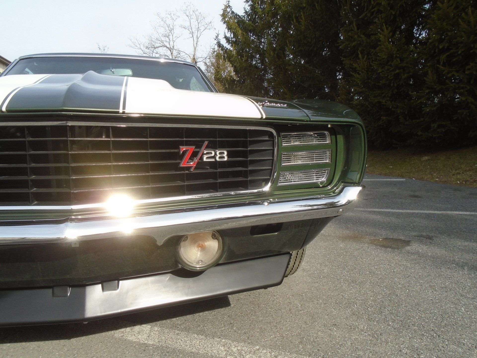 Green and white 1969 Chevrolet Camaro Z/28 sports car, front view, outdoors.
