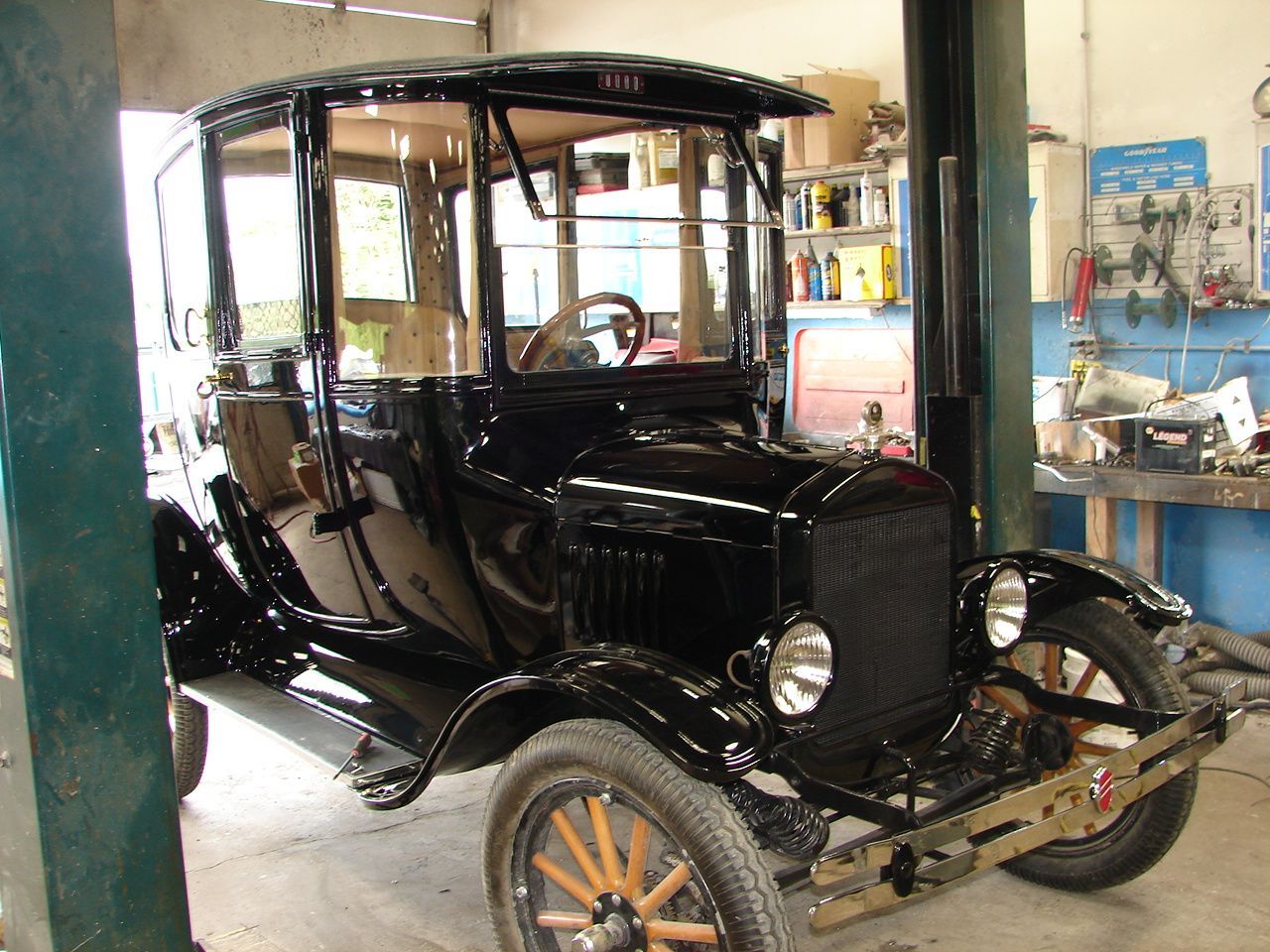 Black Model T Ford car in a repair shop.