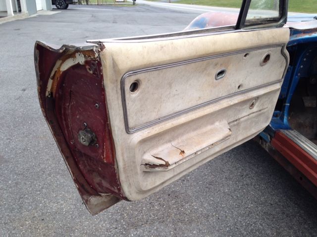 Car door, weathered beige panel, visible hardware, partially open.