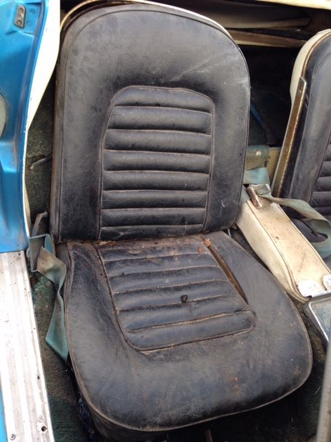 Black car seat, ribbed back and bottom cushions, in a light blue interior.