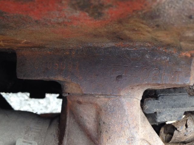 Close-up of a rusted metal component, possibly part of machinery, with an uneven, dark surface.