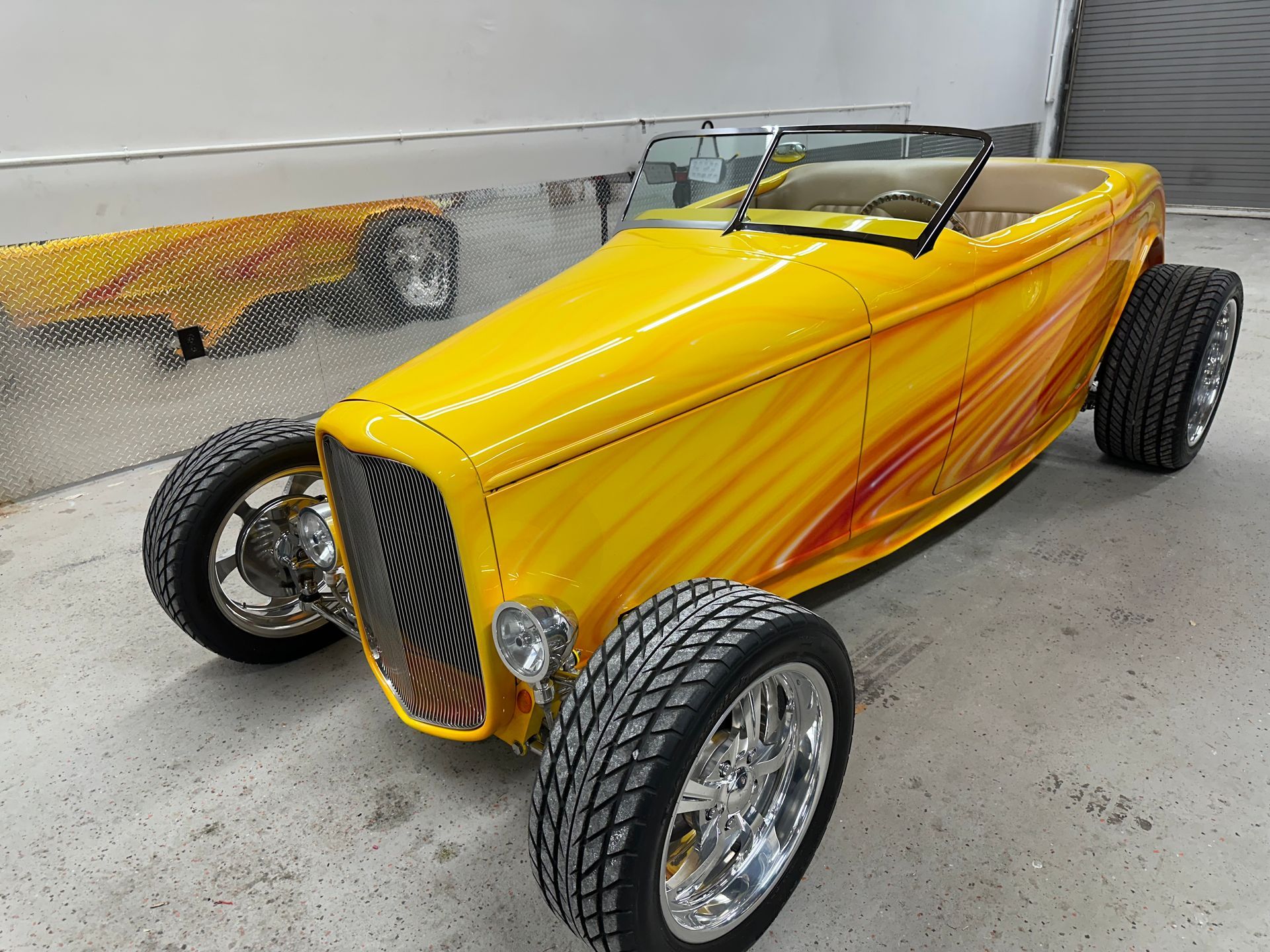 Yellow hot rod with custom paint job and chrome wheels.