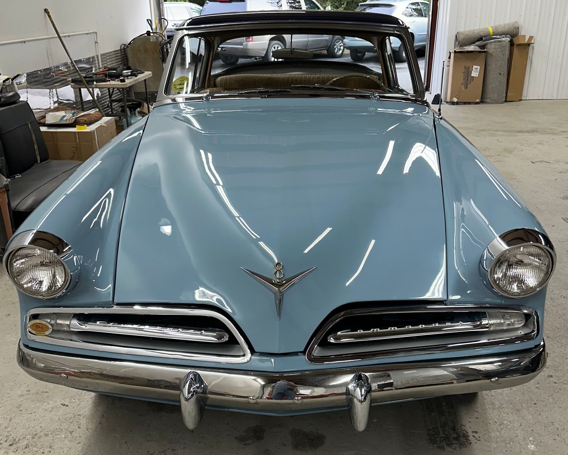 Light blue 1950s Studebaker coupe in a garage, chrome trim, front view.