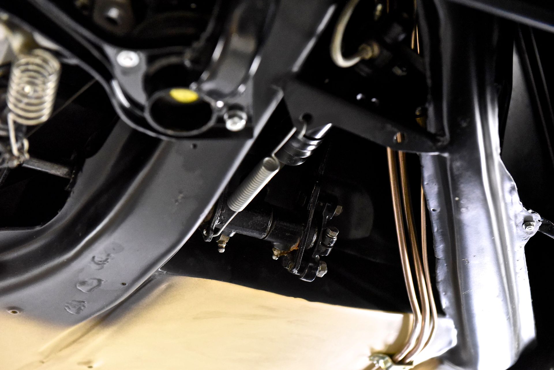 Undercarriage view with brake assembly and connecting rods, black and metallic.