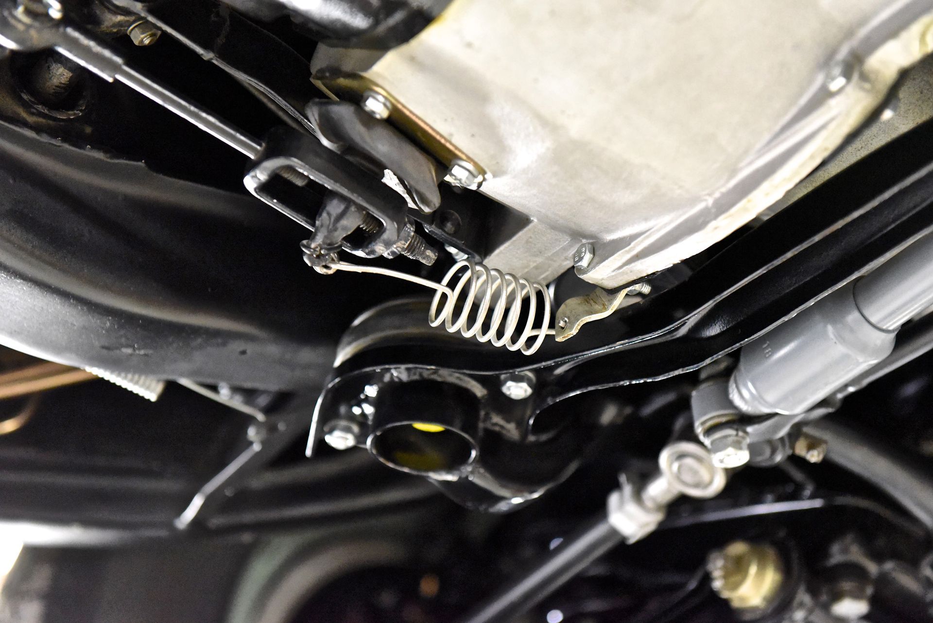 Black car undercarriage with a spring and connecting rods.