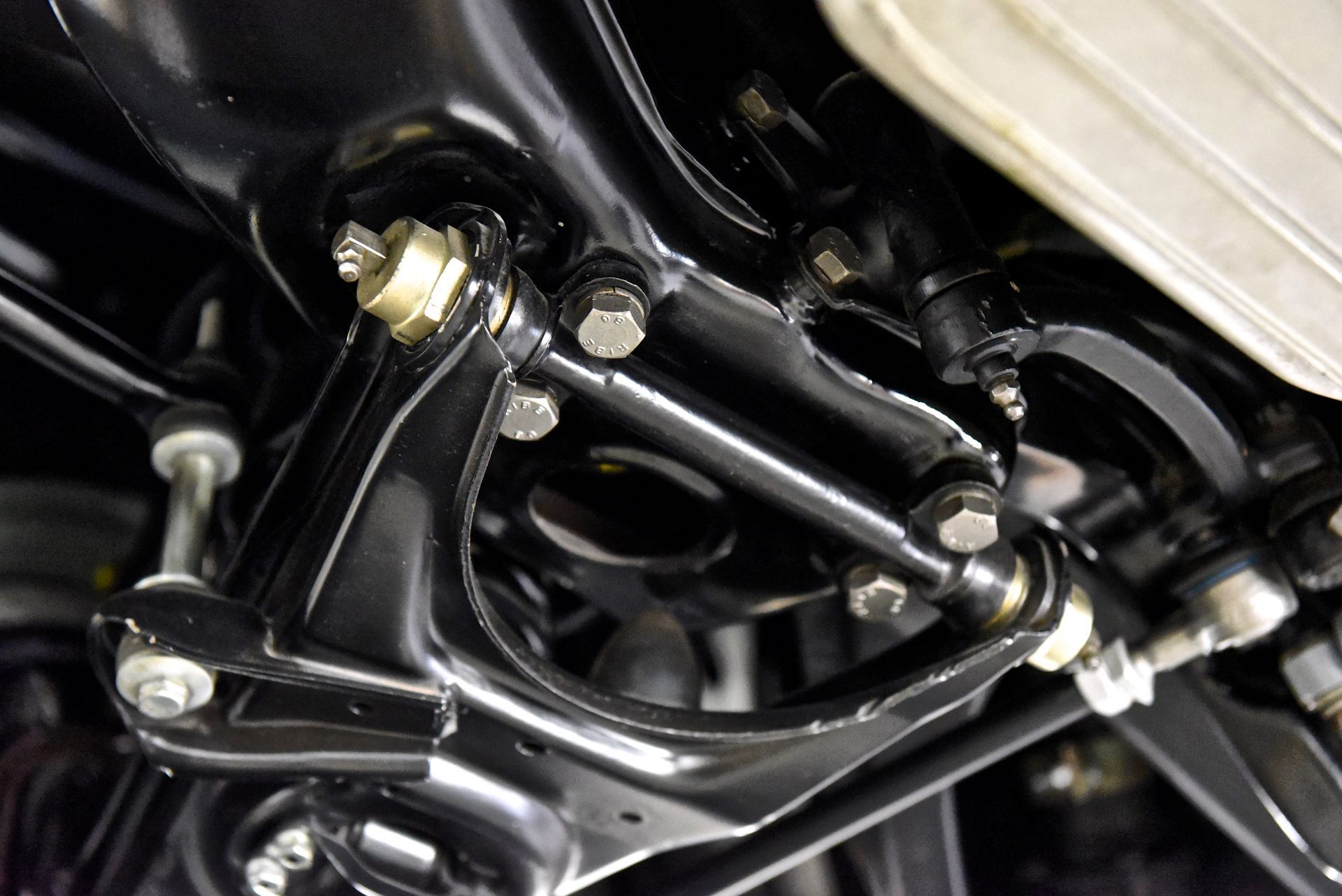 Black car suspension components, bolts, and connecting rods.