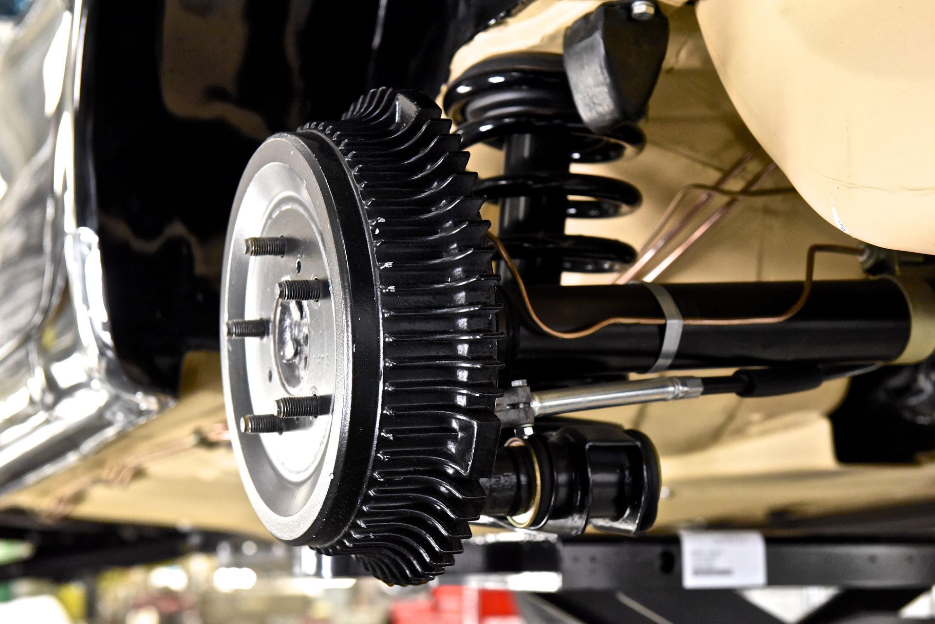 Black drum brake assembly on a car, with shock absorber and suspension components.