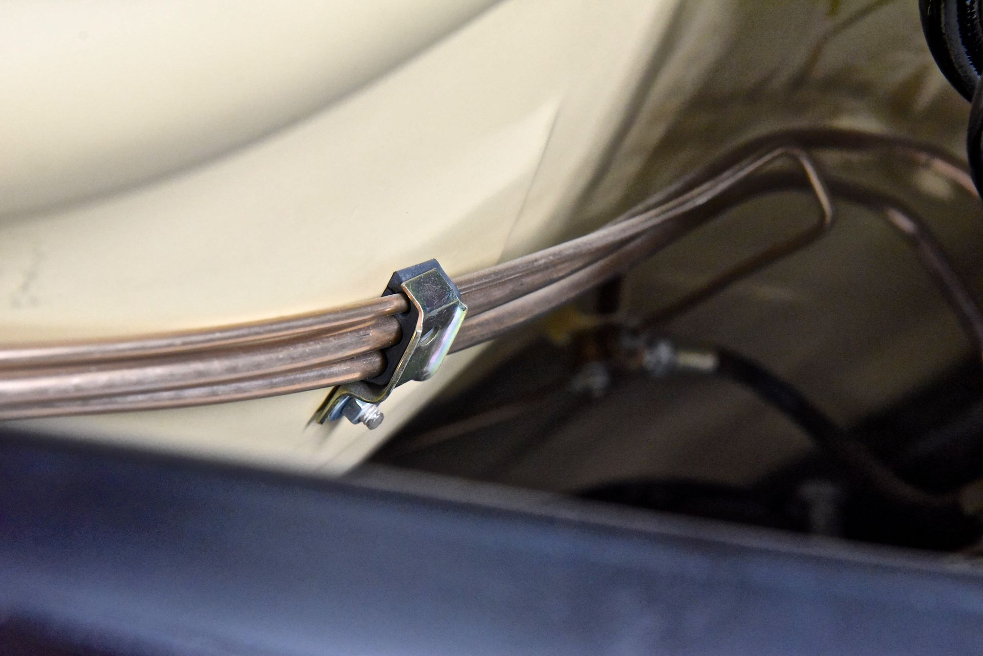 Metal tubes secured by a clamp to a car's chassis.