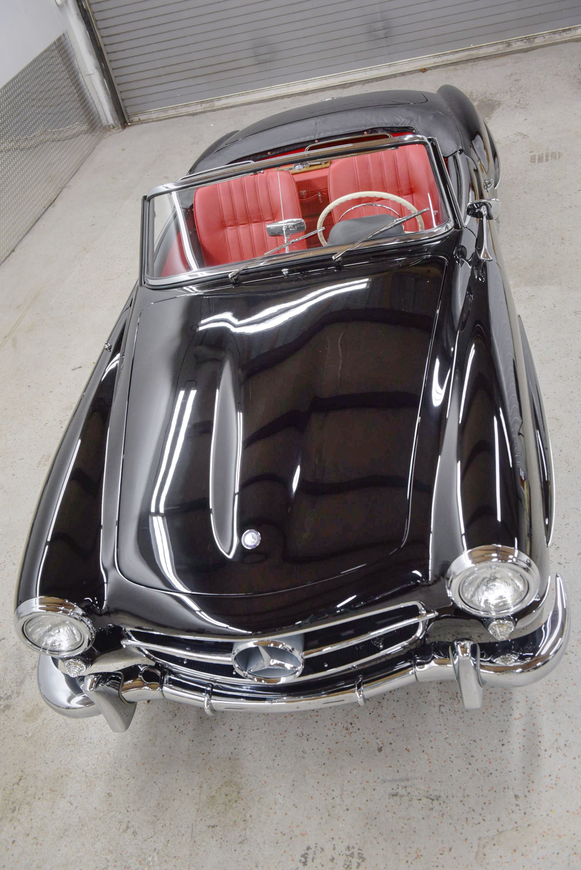 Black classic convertible car with red interior.