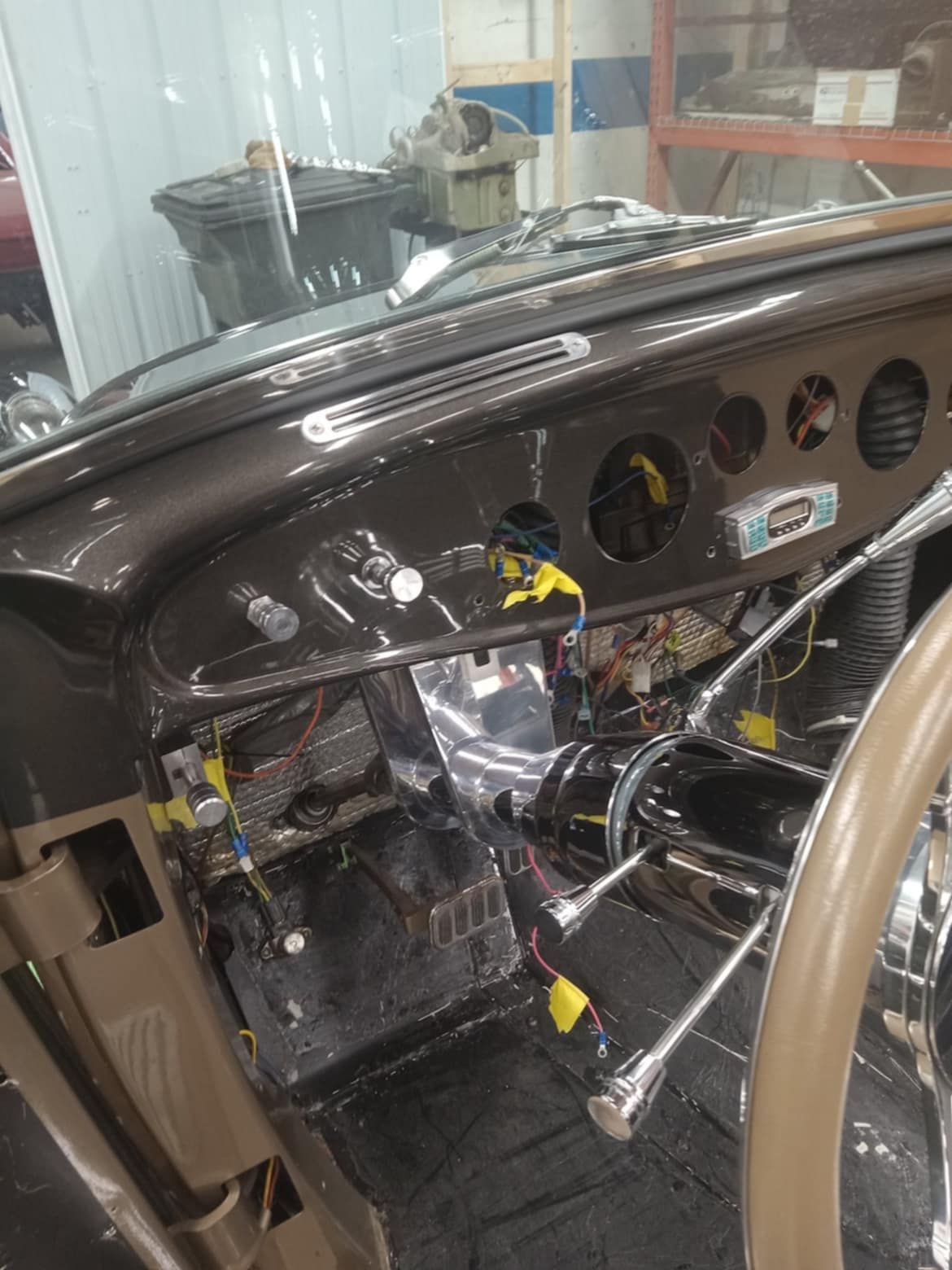 Dashboard of a classic car, with gauges, wiring, and steering wheel visible during restoration.
