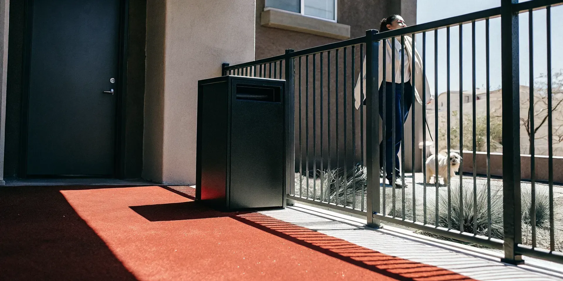 Property manager walking beside a clean pet waste station at a Las Vegas apartment dog run