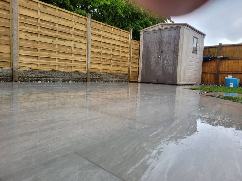 Close-up of Kandla grey large-format porcelain paving with new fencing and a shed in Wyken, Coventry
