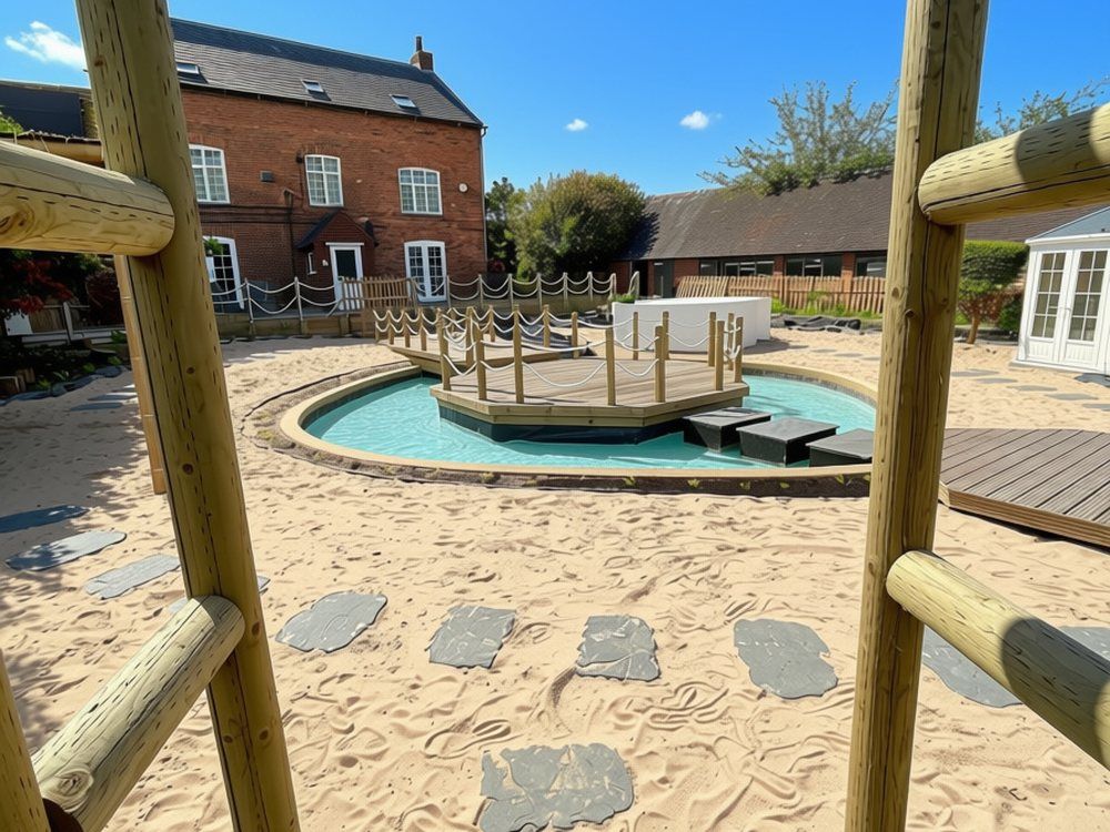 View through a round-pole timber frame across beach sand and slate stepping stones to the lagoon and island deck