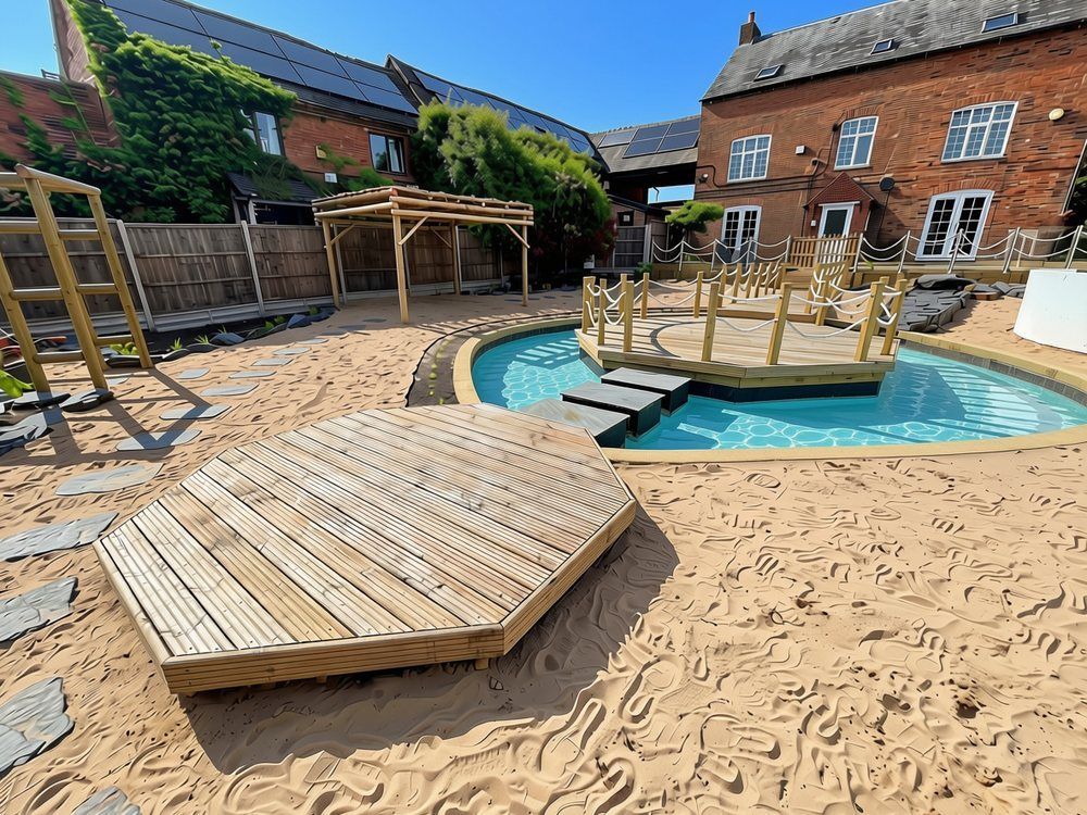 Small octagonal timber deck on beach sand beside the lagoon, with slate stepping stones and a bamboo pergola behind