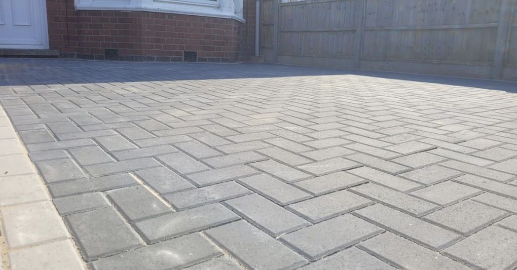 Grey herringbone block paving driveway with a light edging course