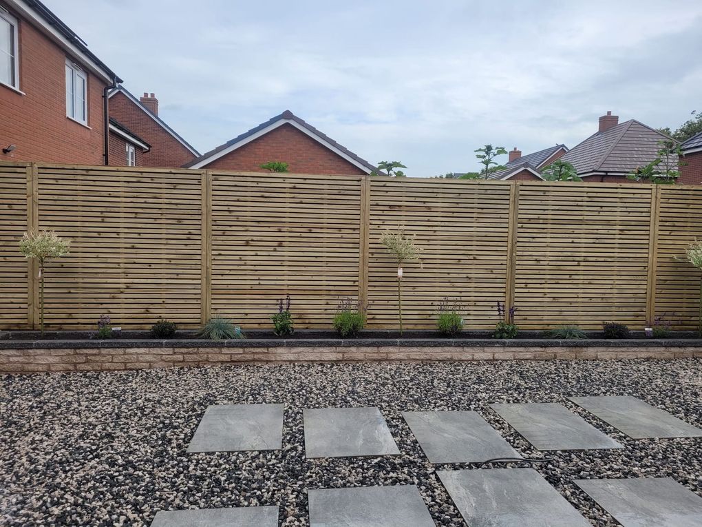 New slatted timber fence behind a gravel garden with paved stepping stones