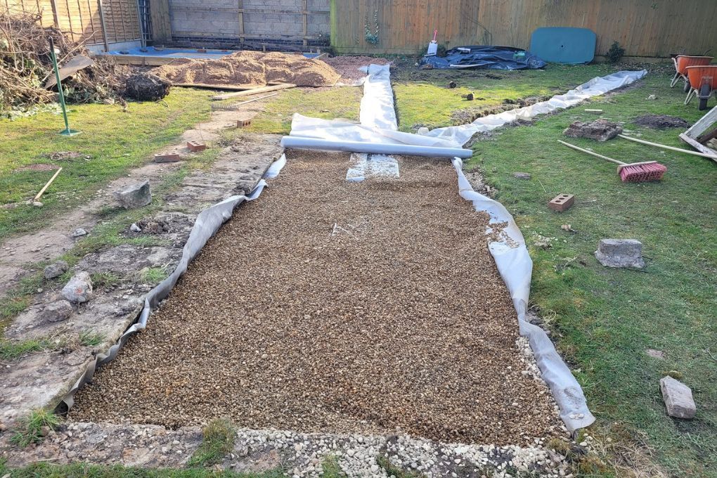 DNA Landscapes garden drainage solutions applying final gravel layer in Leamington Spa