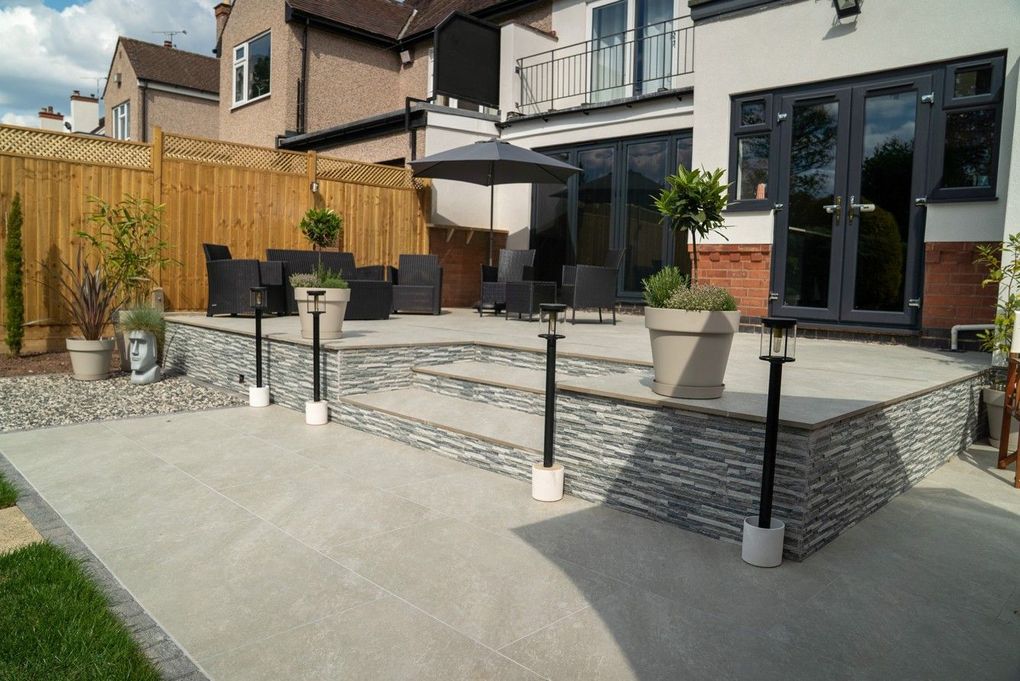 Lower terrace in the finished Earlsdon garden with steps rising to the upper level and lantern posts along the edge