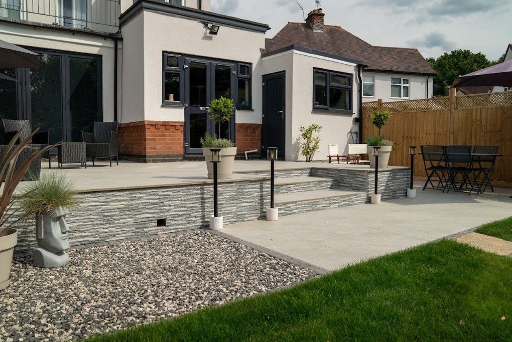 Steps and retaining wall faced in split-face grey stone cladding, with gravel and new lawn, in the finished Earlsdon garden