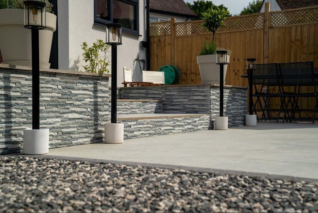 Black lantern posts along the stone-clad edge of the Earlsdon terrace, with gravel in the foreground