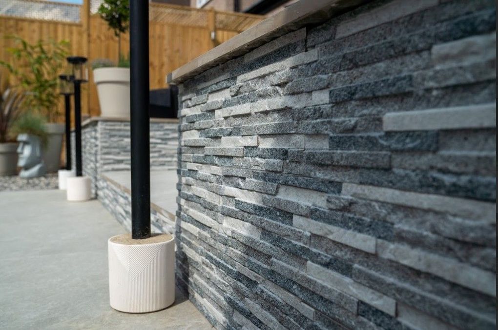 Close-up of split-face grey stone cladding and a lantern post on the finished Earlsdon terrace
