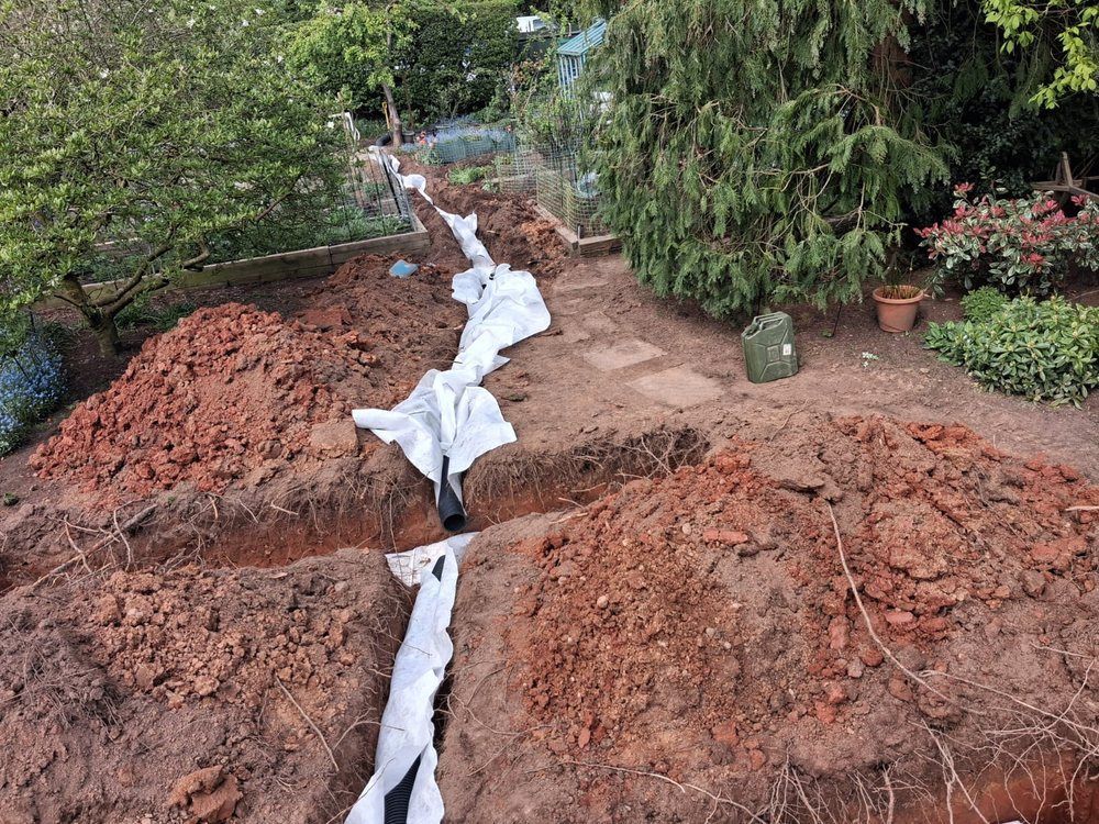 Land drainage trench lined with geotextile membrane before aggregate is added