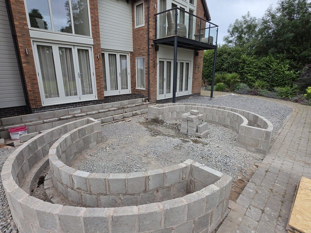 Circular blockwork planter under construction on a gravel base beside the house at Chestnut House, Lapworth