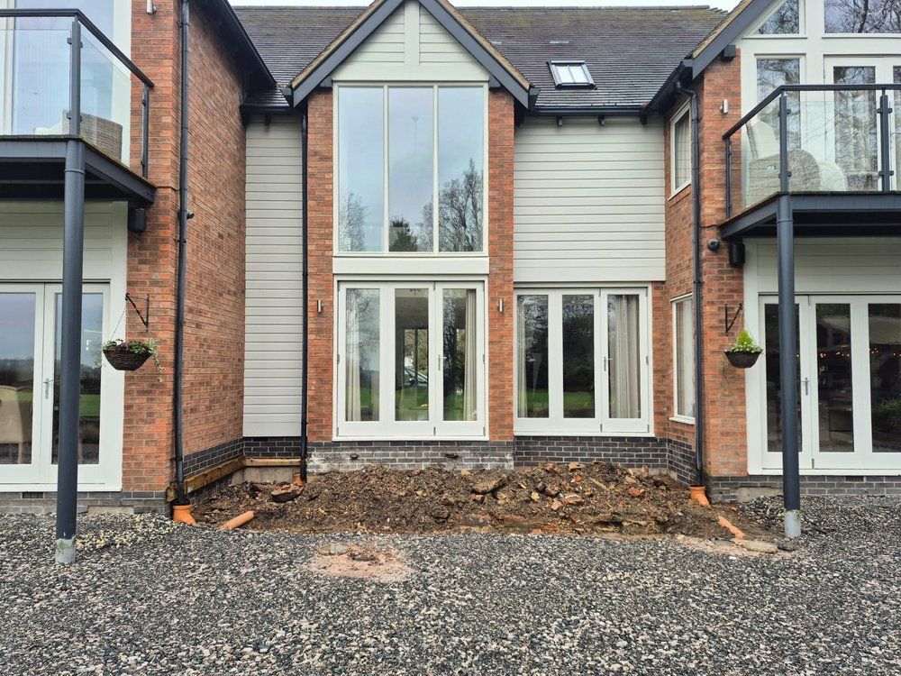 Rear elevation of Chestnut House, Lapworth, with rubble and gravel where the new porcelain terrace would be laid