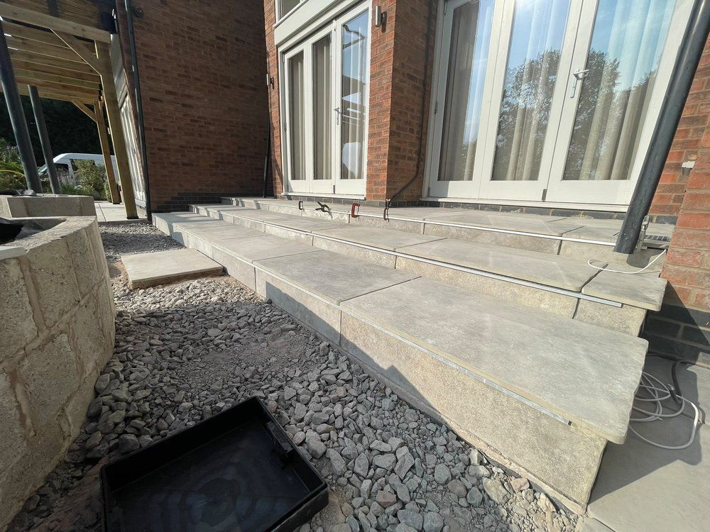 Porcelain feature steps with bullnose edging under construction, leading from the house down to the garden