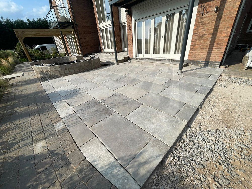 Large-format Wexford Natural porcelain paving being laid across the rear terrace at Chestnut House, Lapworth