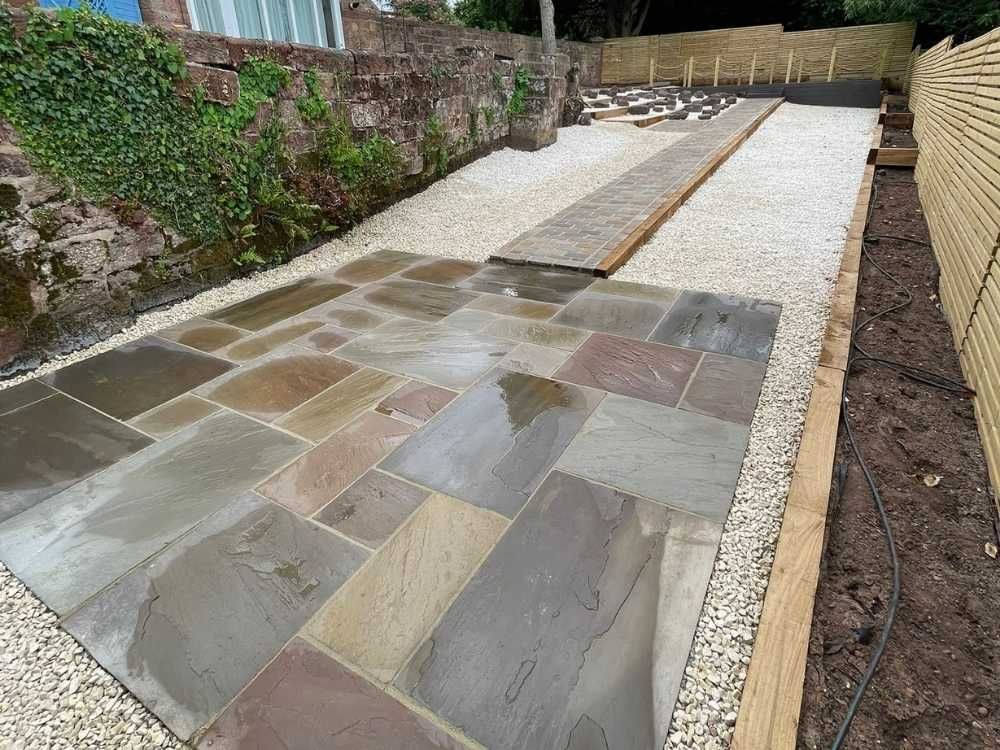 Wet Autumn Brown sandstone paving with a sandstone setts pathway, white gravel and original ivy-clad stone wall