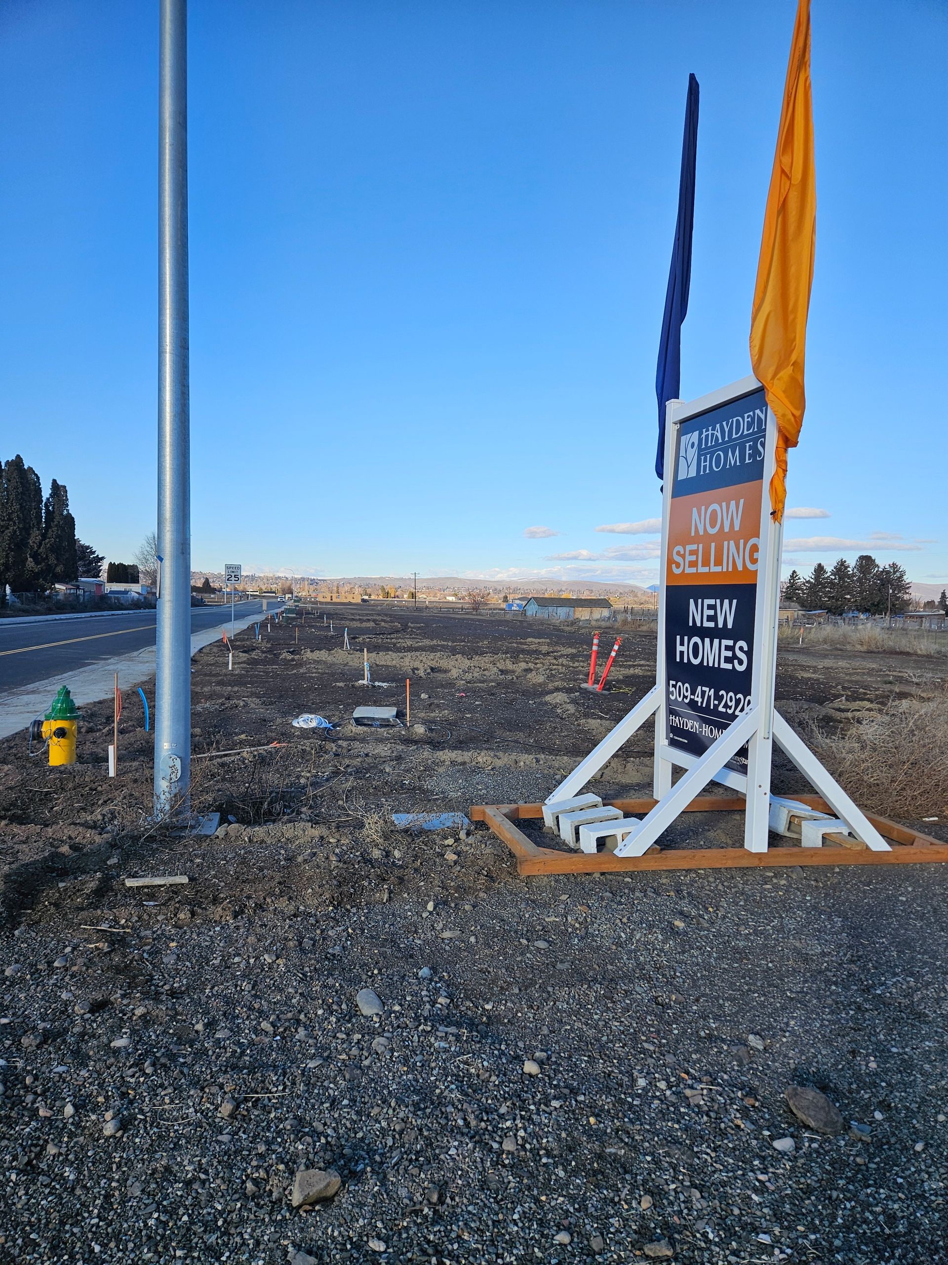 Sign marking a new shoreline in a rocky coastal area under a clear blue sky