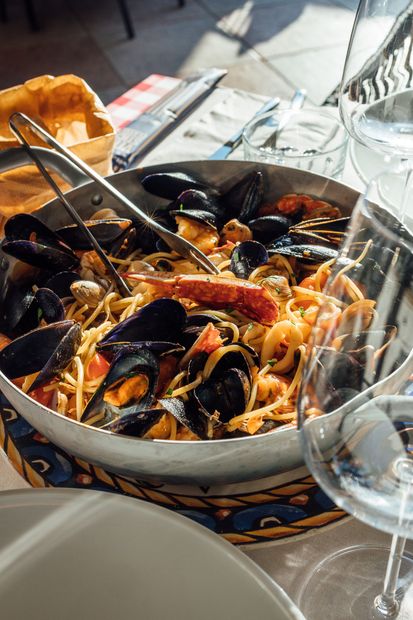 Piatto di pesce alla griglia servito su un piatto, con vista sull'acqua e sui fiori.