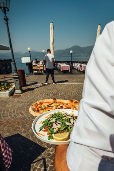 Pizza con crosta dorata e glassa bianca su un piatto con bordo blu.