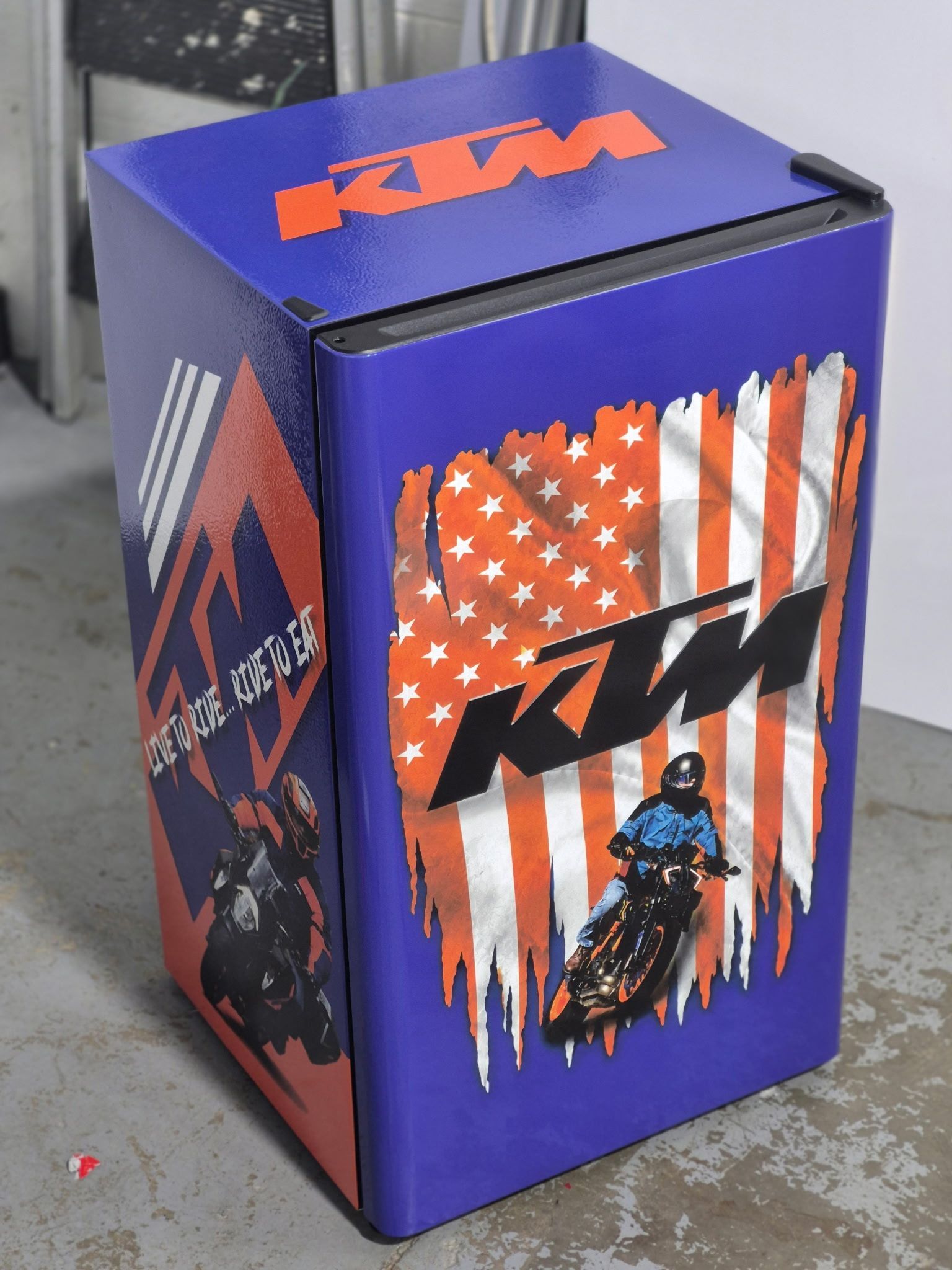 Purple KTM-branded display box with orange and white graphic decals on a concrete floor
