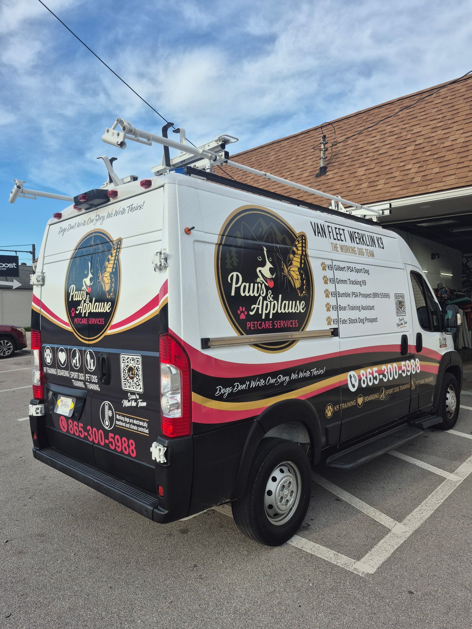 Branded white-and-black van parked outdoors under a blue sky with power lines overhead
