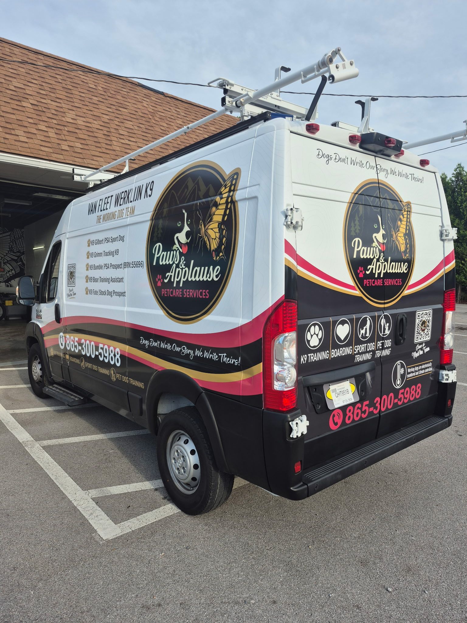 White service van with black and red graphics parked outside a building, side and rear view