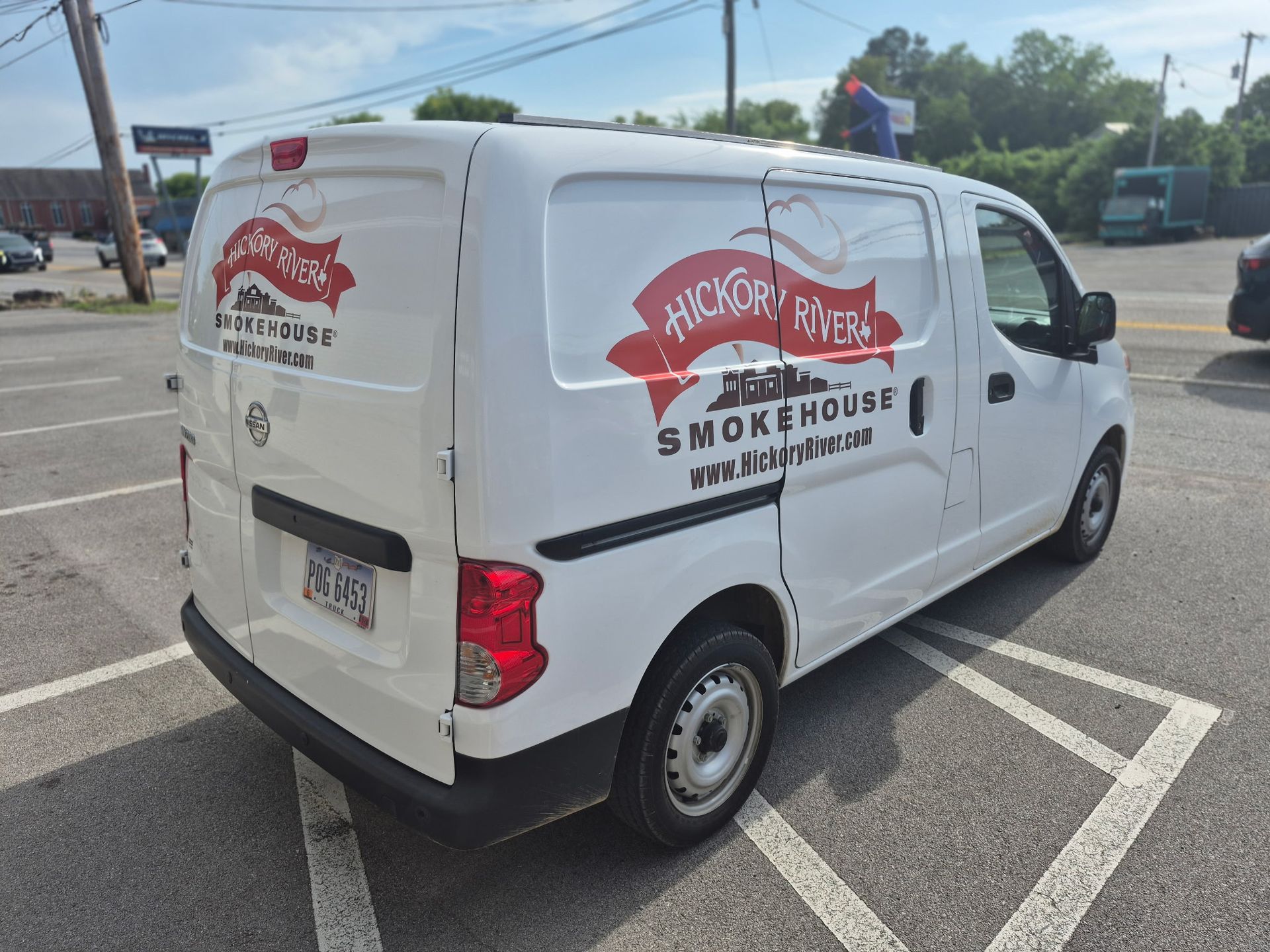 White Smokers’ Smokehouse delivery van parked in a lot, with red logo and text on the side.