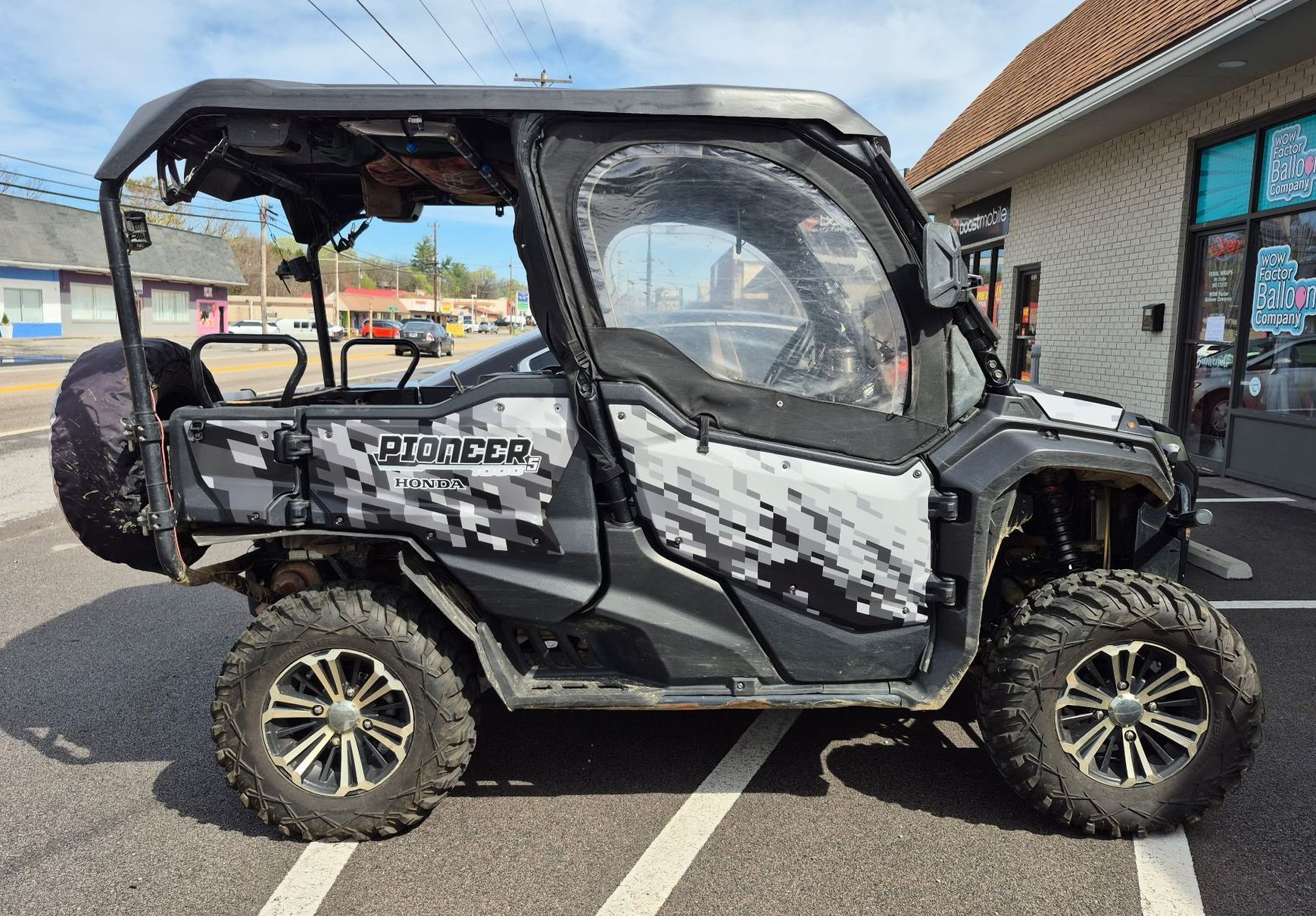 A honda atv is parked in a parking lot in front of a building.