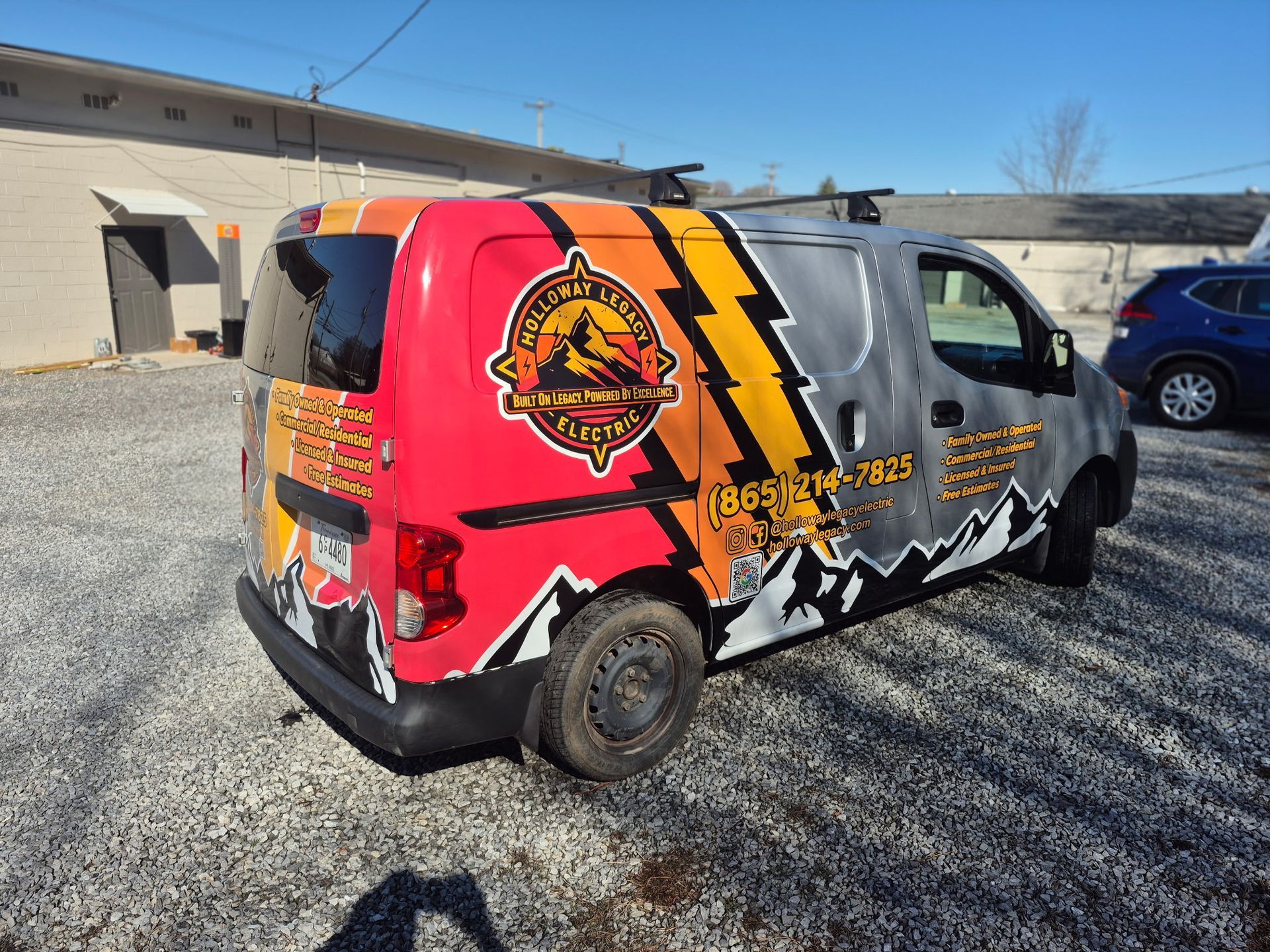 Van with company logo wrap, featuring mountain and lightning bolt design.
