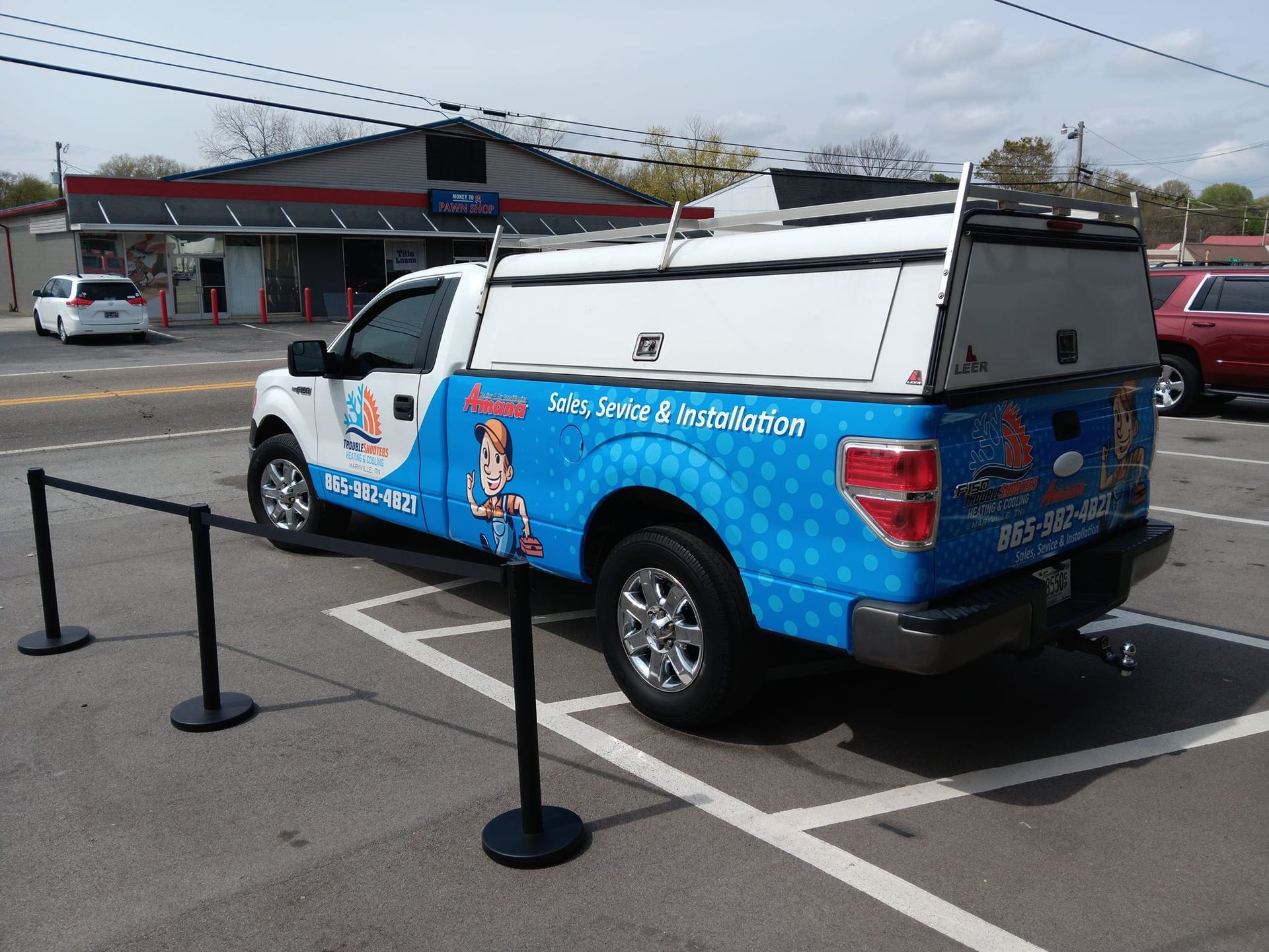 A blue and white truck is parked in a parking lot