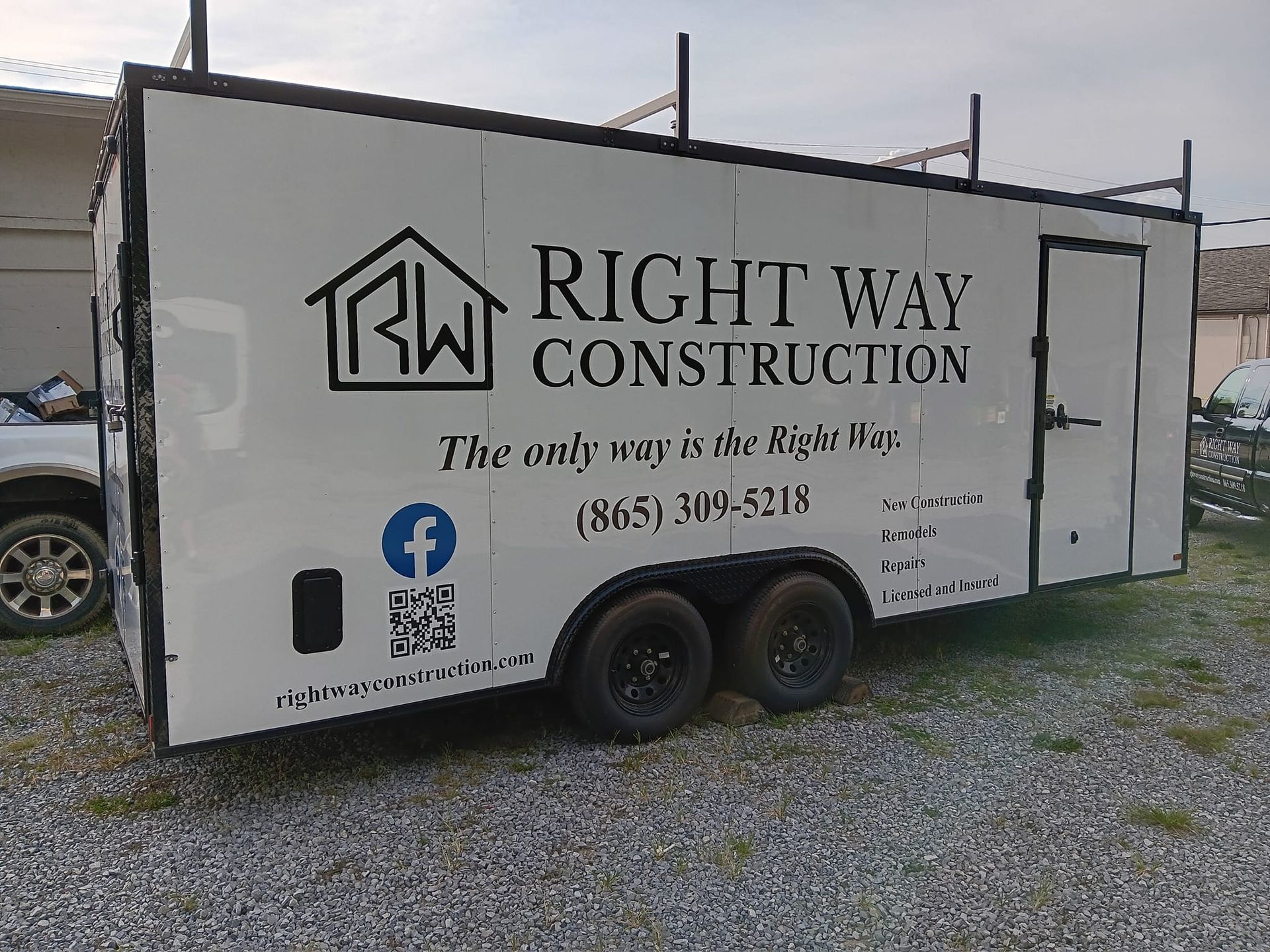 A trailer for right way construction is parked in a gravel lot.