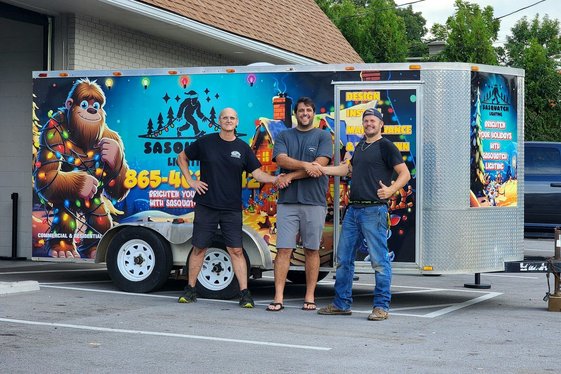 Three men are standing in front of a trailer that says 365-40