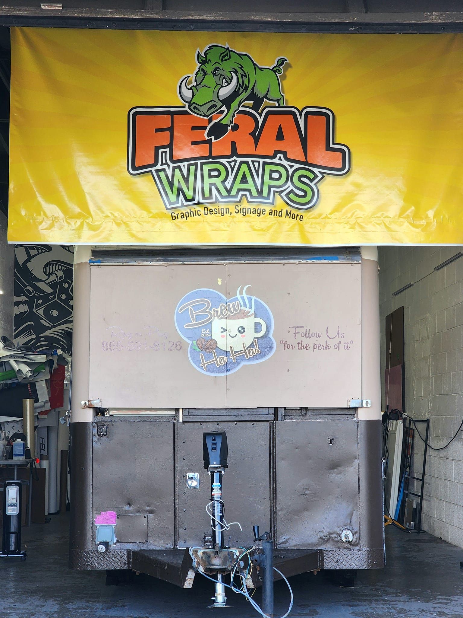 A truck is parked under a banner that says feral wraps